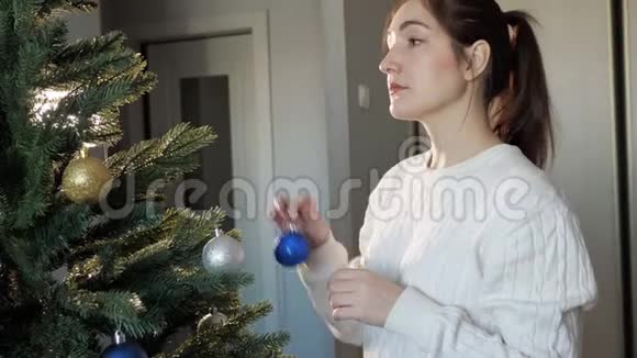 扎着马尾装饰圣诞树的快乐小姐视频的预览图