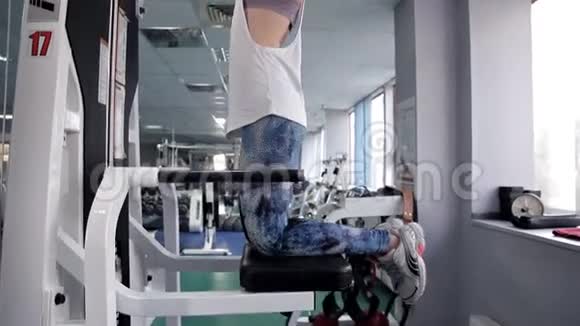 运动的女人在健身房锻炼手背的肌肉旋转门那个锻炼身体的女孩视频的预览图