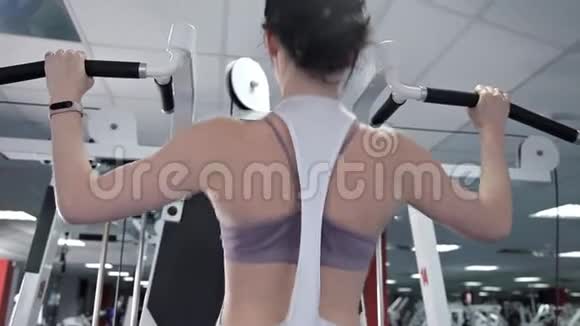 运动的女人在健身房锻炼手背的肌肉旋转门那个锻炼身体的女孩视频的预览图