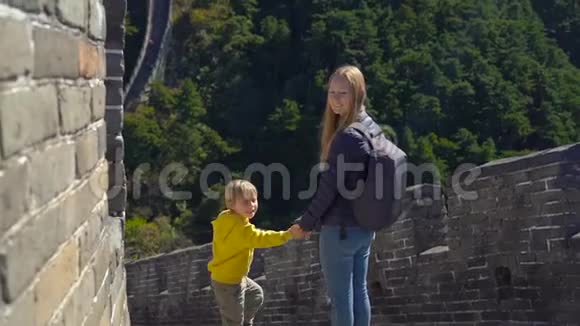 一位幸福的年轻女子和她的小儿子站在中国长城上的慢镜头视频的预览图