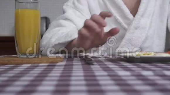 男人手切鸡蛋躺在盘子上用叉子和刀关起来橙汁杯和花瓶视频的预览图