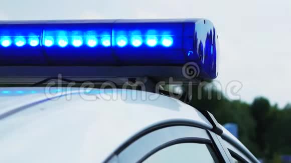 白天闪烁着蓝色的闪光灯警察巡逻车关门视频的预览图