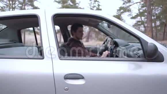 欧洲男人使用智能手机坐在车舱里视频的预览图
