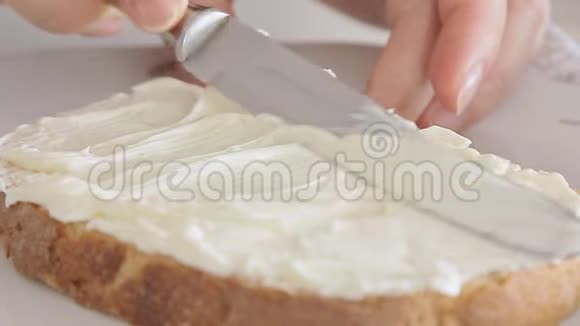 女人的手在面包片上撒起司视频的预览图
