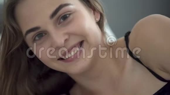 描绘了一个美丽年轻快乐的白种人女人两只不同颜色的眼睛躺在床上遮住了她的脸视频的预览图