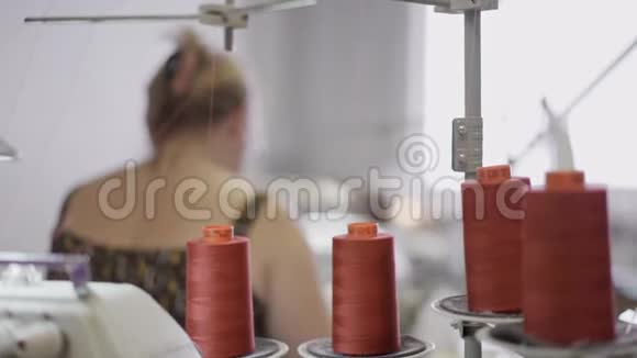 在女裁缝的背景上合上四个橙色线轴视频的预览图