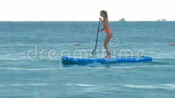 女运动员用桨板和波浪溅入照相机视频的预览图