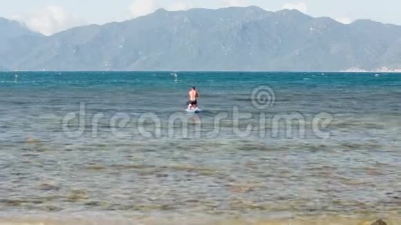 一个人站在膝盖上划着桨划着大海视频的预览图