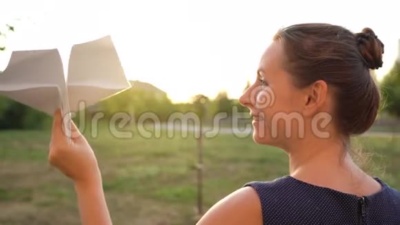 女人在日落的背景下发射纸飞机梦想旅行或空姐的职业慢慢视频的预览图