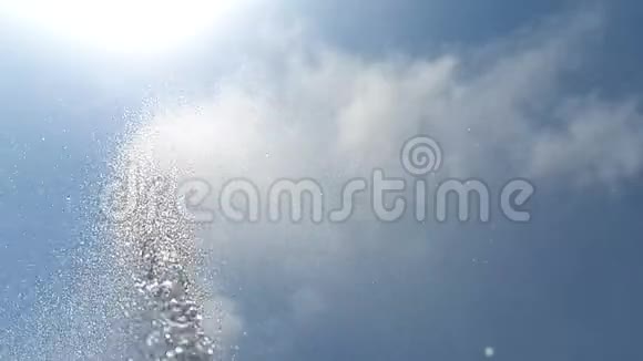 在蓝天白云的背景下一股水在缓慢地流动在周围洒落视频的预览图