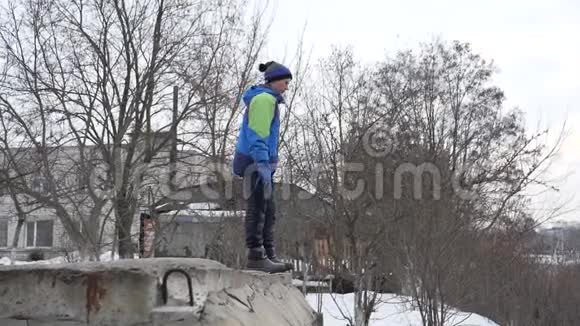青少年在冬天从一个高度跳跃视频的预览图