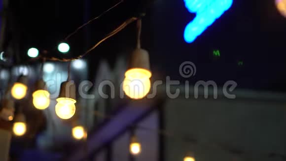 带有蓝色霓虹灯背景的亚洲夜市的节日灯泡花环视频的预览图