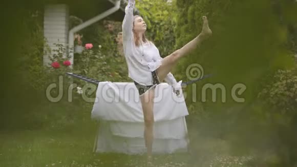 快乐可爱的年轻女人在后院唱歌跳舞同时做家务和亚麻布洗衣日视频的预览图