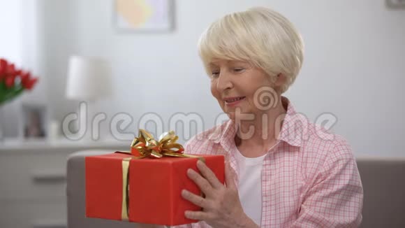微笑的老年女性手拿礼盒幸福妇女节庆典视频的预览图