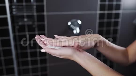 为女性在淋浴时的手皮肤化妆品水化和营养皮肤敷奶油面膜的特写镜头视频的预览图