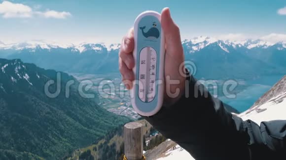 手拿着一个温度计在瑞士阿尔卑斯山的顶端罗瑟斯德纳伊视频的预览图
