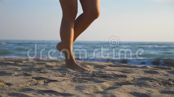 在阳光明媚的日子里女性赤脚在海滨行走年轻女子踩在沙滩上的腿光脚女孩在海岸视频的预览图