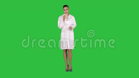 年轻的拉丁医生休息一下在绿色屏幕上喝咖啡Chroma键视频的预览图
