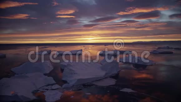 格陵兰冰峡带冰山的自然景观午夜太阳日落地平线日出空中无人机视频的预览图