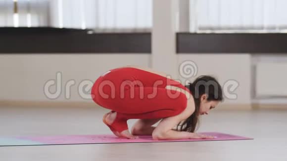 穿红色运动服在工作室做瑜伽的瘦女孩视频的预览图
