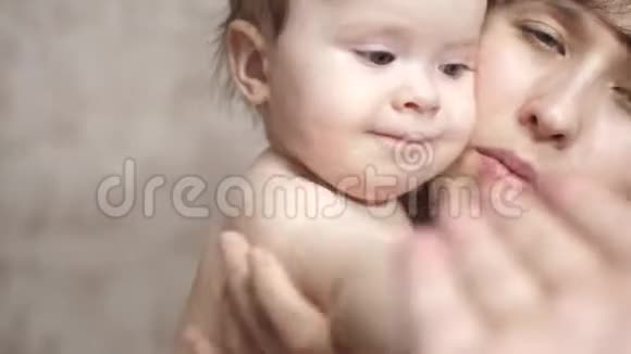 妈妈把婴儿抱在怀里宝宝玩爸爸拍拍爸爸的手视频的预览图