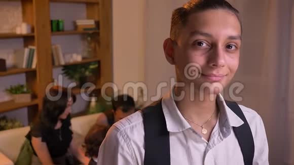 十几岁的阿拉伯男孩直接对着镜头观看的肖像带着谦虚的微笑和他的家庭背景视频的预览图