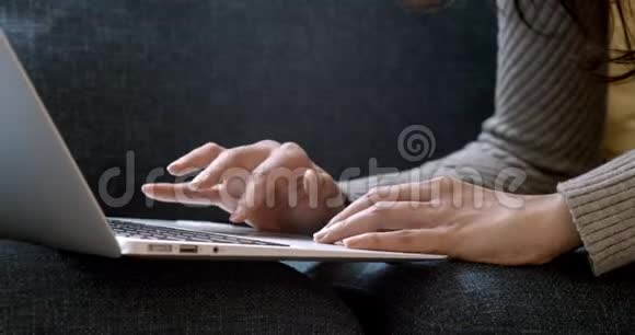 在沙发上用笔记本电脑打字的远程女工视频的预览图