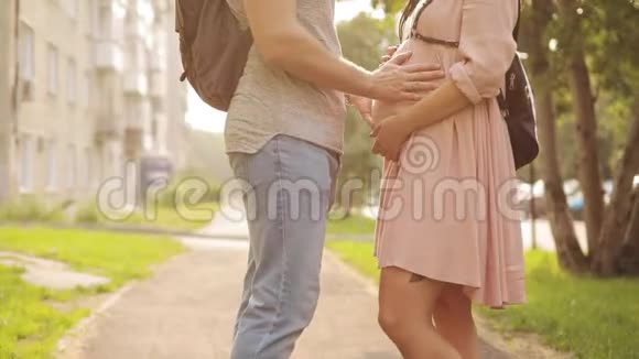 男人手摸着他孕妇的腹部站在街上特写视频的预览图