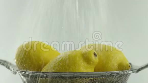 在视频中我们看到柠檬一股水流从顶部涌出白色的背景视频的预览图