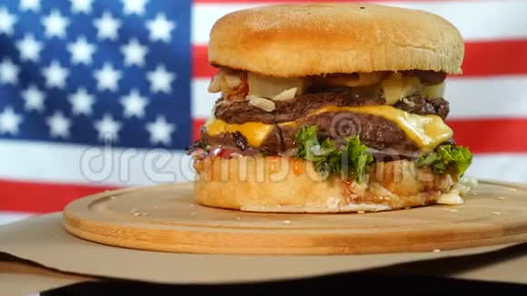 烤美国牛肉汉堡配生菜奶酪洋葱放在木制柜台上旋转的棕色纸上视频的预览图