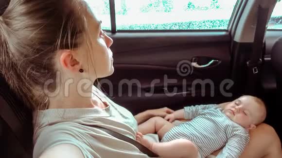 坐在车里的女人腿上有个熟睡的孩子视频的预览图