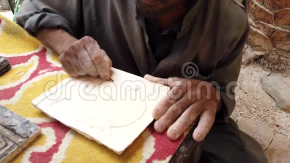 男子雕刻图案上的粘土片装饰视频的预览图