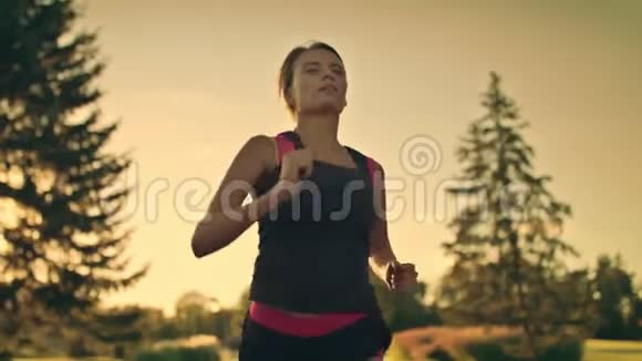 在夏季公园晚上运动女子训练跑步擦额头上的汗视频的预览图