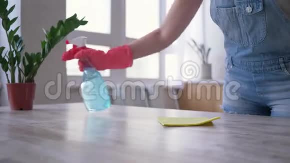 家务活戴手套的女孩手里拿着一瓶洗涤剂和布在厨房擦桌子视频的预览图