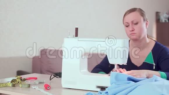 一个裁缝在家里的桌子上工作与一台白色缝纫机她创造新衣服慢动作视频的预览图