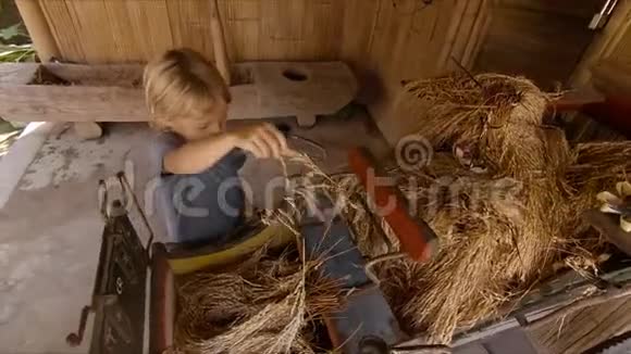 一个小男孩玩一种古老的大米处理工具的慢镜头视频的预览图