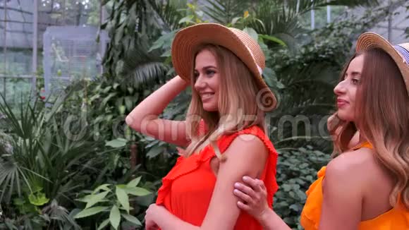 在植物园摆姿势的戴着帽子的金发女孩的肖像视频的预览图