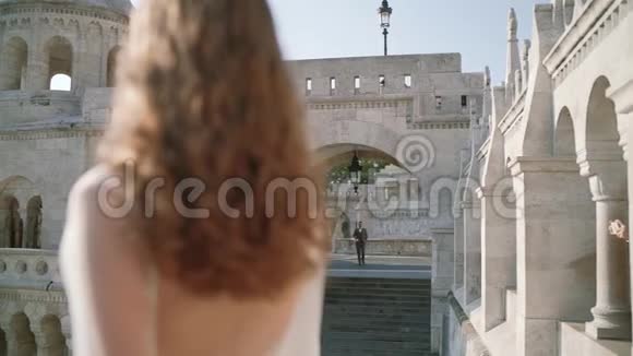 一位非常漂亮的年轻女子或新娘穿着白色的裙子呆在老城堡的阳台上看看新郎是如何视频的预览图