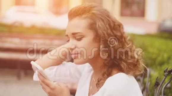 美丽的女人使用智能手机技术应用在城市街道生活的城市快乐生活方式日光背景视频的预览图