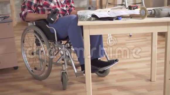 一个坐轮椅的残疾人的肖像手里拿着电动螺丝刀视频的预览图