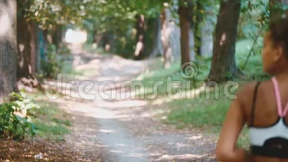 年轻的健身女子在森林小径跑步视频的预览图