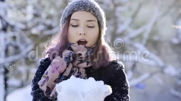 快乐的亚洲女人对着镜头吹雪冬季体育假日关系爱情圣诞节生活方式视频的预览图