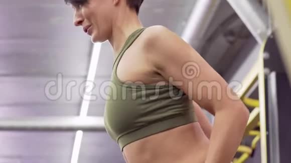 美丽的年轻女性健身模特穿着紧身衣练习的侧视图视频的预览图