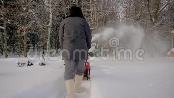 后景男子清雪机背景冬季森林视频的预览图