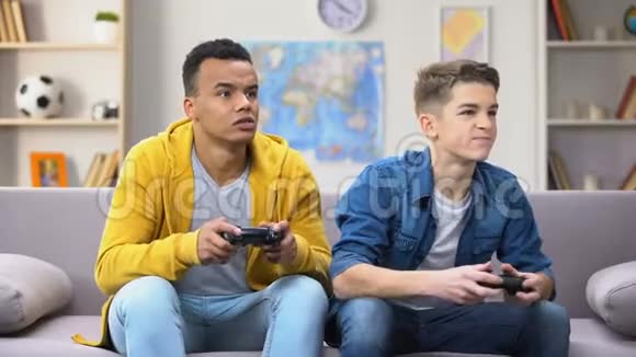 情感上的多种族男性青少年朋友玩电子游戏爱好和竞争视频的预览图