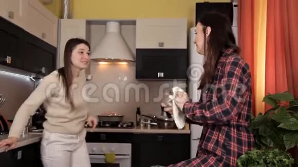 两个年轻女孩一边做饭一边在厨房聊天社区朋友食物视频的预览图