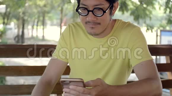 慢动作4k的休闲亚洲男子使用智能手机视频的预览图