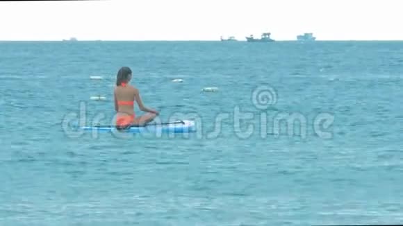 比基尼女郎坐在船上的冲浪板视频的预览图