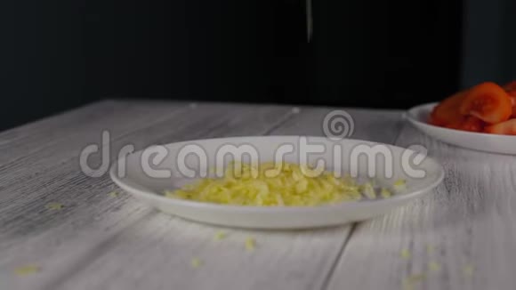 特写细碎的奶酪落在白色的盘子里视频的预览图