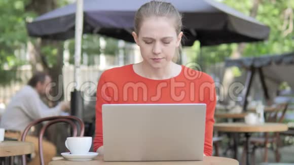 戴头巾的年轻女子坐在咖啡厅露台上视频的预览图